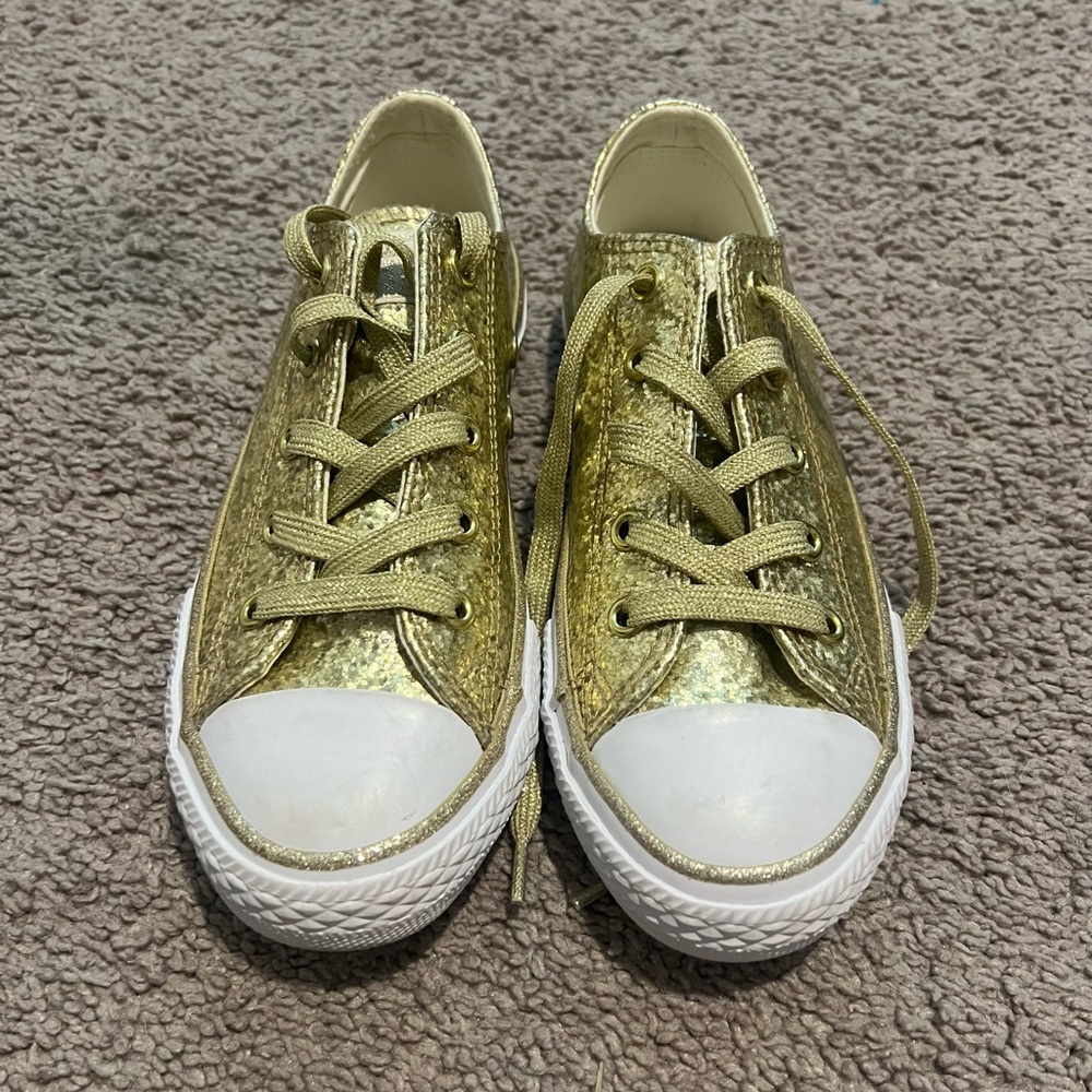 Sparkly gold low top converse.